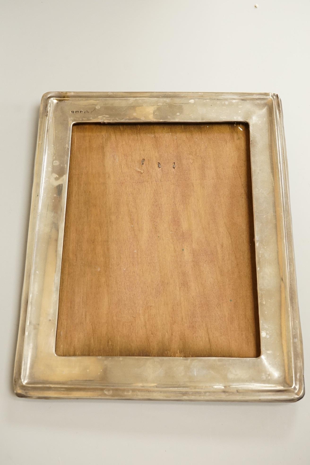 Four assorted early 20th century silver mounted photograph frames, the largest by Sanders & Mackenzie, Birmingham, 1915, 30.3cm by 21.6cm, together with two small Spanish white metal mounted photograph frames.